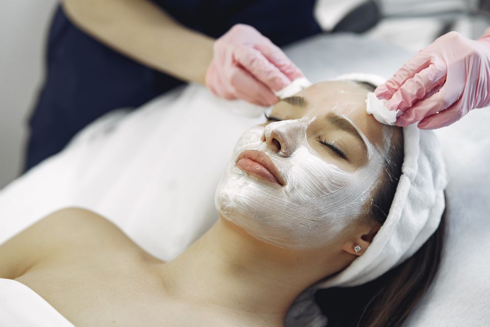 A woman receiving a facial mask treatment; open larger image
